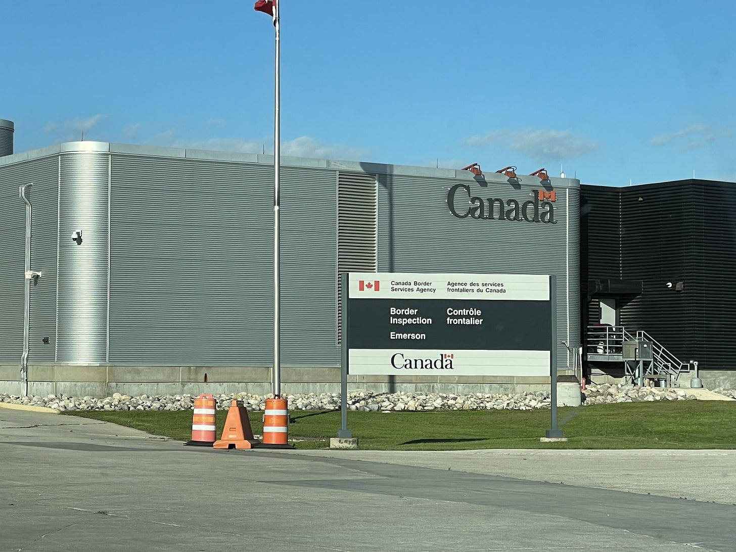 A large metal building with the word Canada in big letters on the top right corner of the building