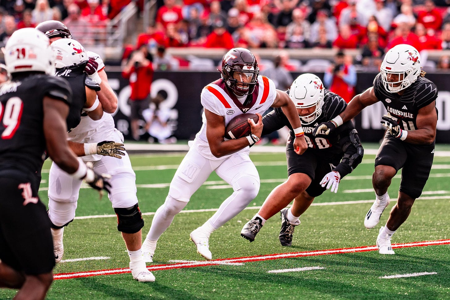 Virginia Tech quarterback Kyron Drones is pressured by Louisville defenders. Virginia Tech quarterback Kyron Drones is pressured by Louisville defenders.