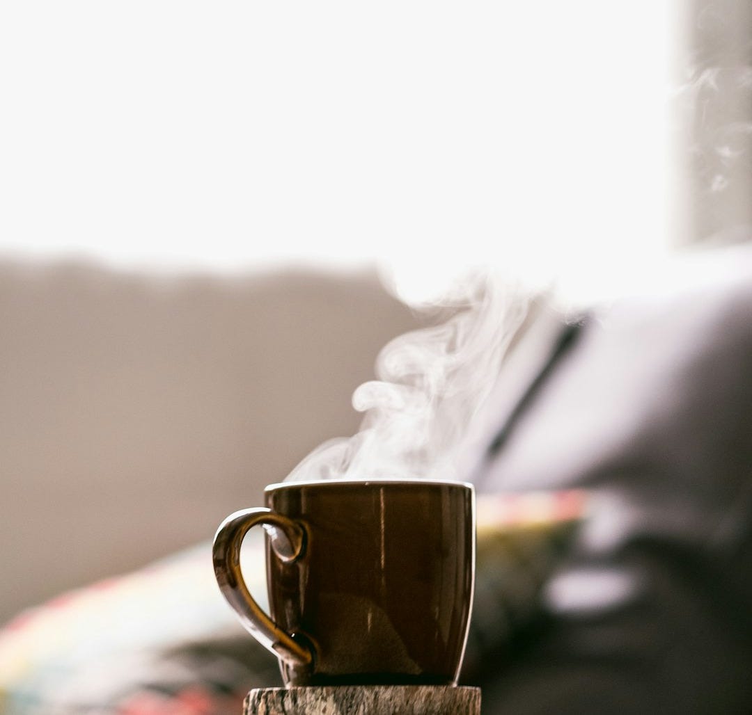 shallow focus photography of hot coffee in mug with saucer