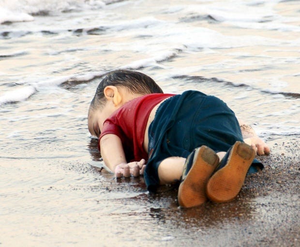 A young migrant, who drowned in a failed attempt to sail to the Greek island of Kos, lies on the shore in the Turkish coastal town of Bodrum, Turkey. REUTERS/Nilufer Demir/DHA