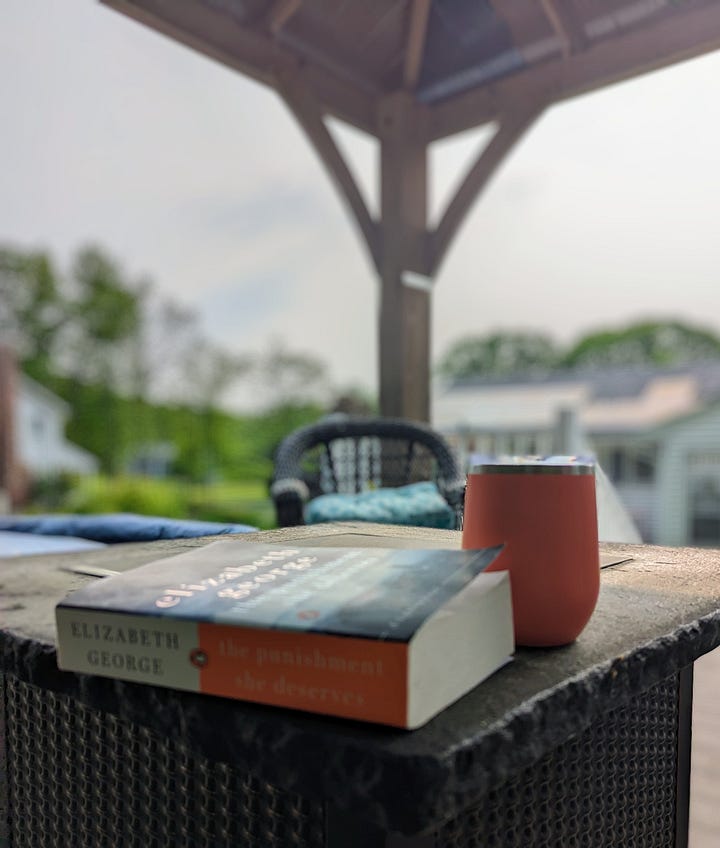 cat resting on a book, book on deck table