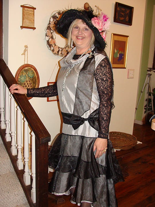Photo of the author in a flapper dress she made herself, and an elaborate hat.