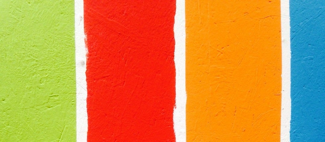 four orange, green, blue, and red paint rollers