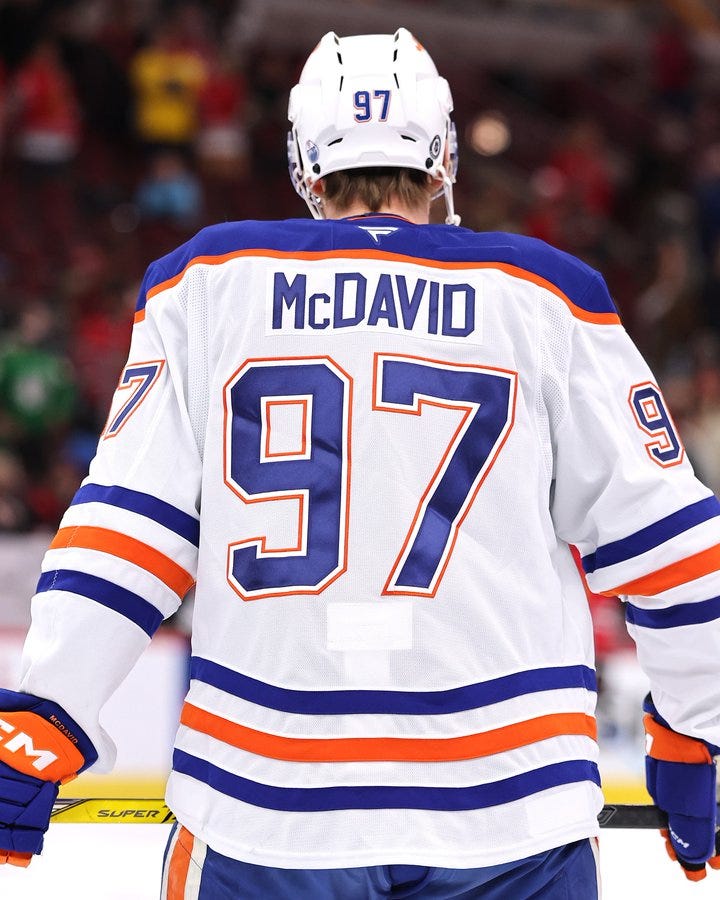 A photo of Connor McDavid from behind in an Edmonton Oilers uniform. A photo of Connor McDavid from behind in an Edmonton Oilers uniform.