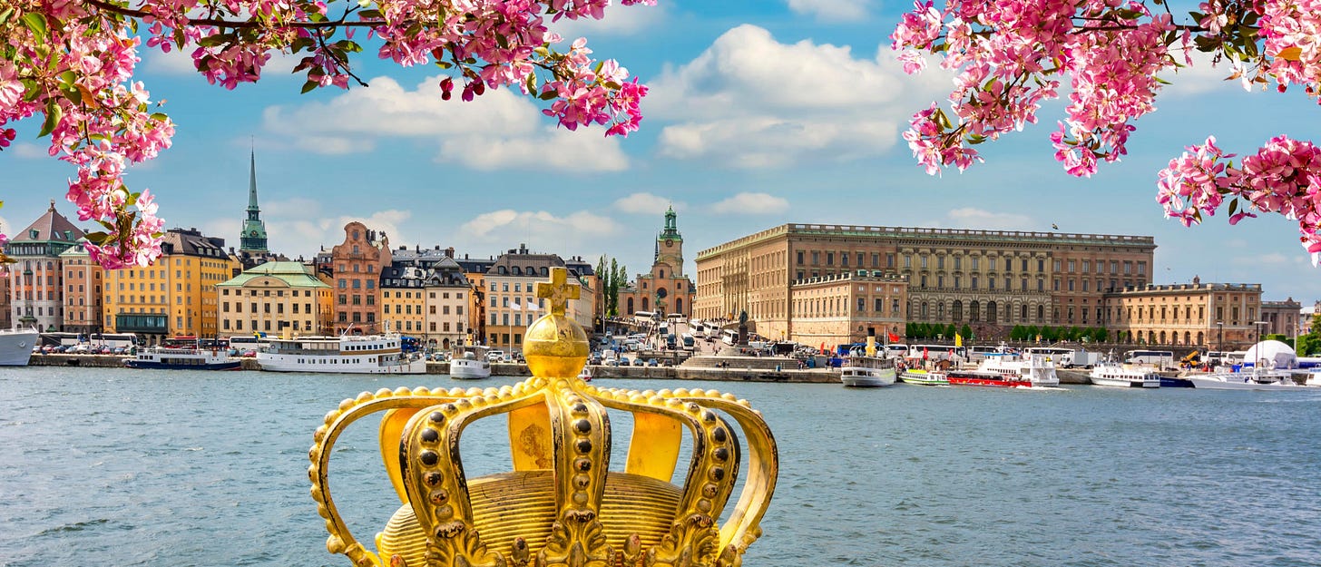 A golden crown on a bridge with a view of Stockholm's old town and Royal Palace