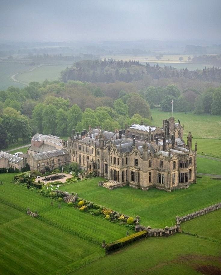This may contain: an aerial view of a large building in the middle of a lush green field This may contain: an aerial view of a large building in the middle of a lush green field