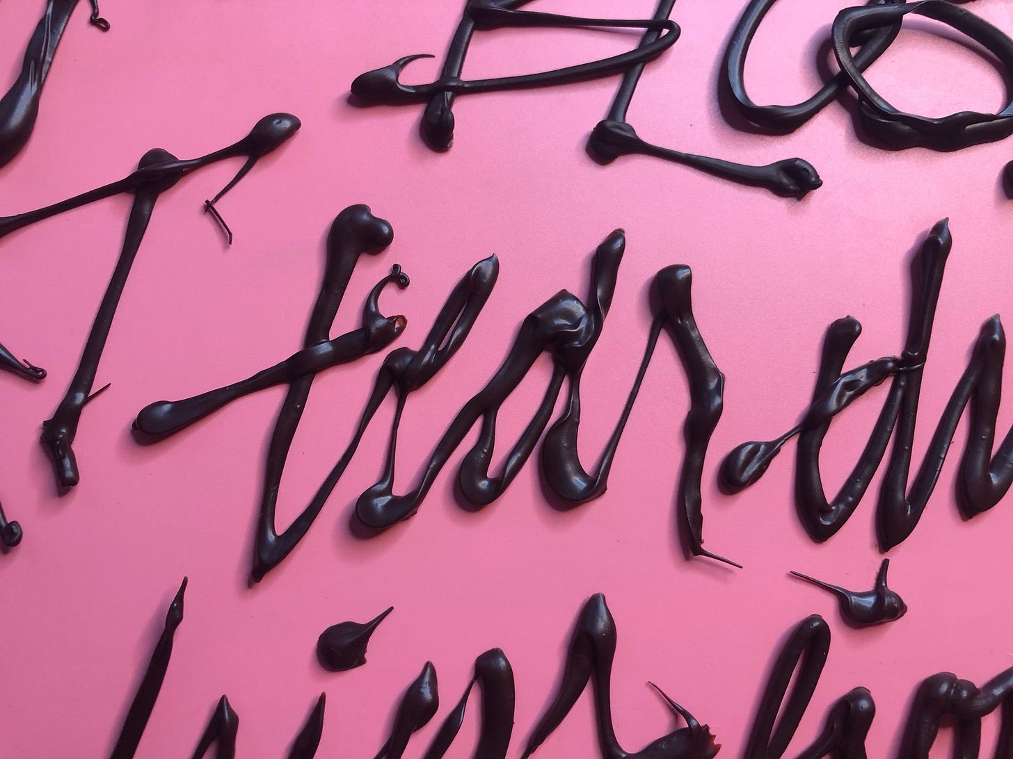 Dark chocolate words on a smooth background that says "tear" in an aggressive script