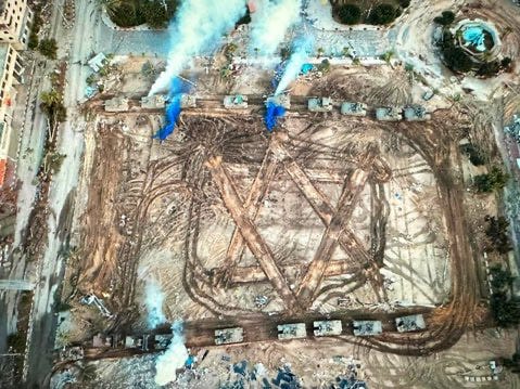 Satellite imagery captures an Israeli tank formation etching a vast Star of David into the rubble of Gaza. A symbol of conquest branded onto a wound, visible from orbit — spectacle by demolition, history turned into propaganda terrain.