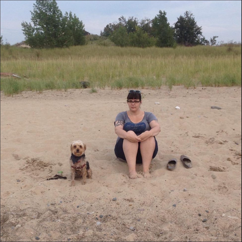 Me and a small brown and black dog sitting next to each other on a beach Me and a small brown and black dog sitting next to each other on a beach