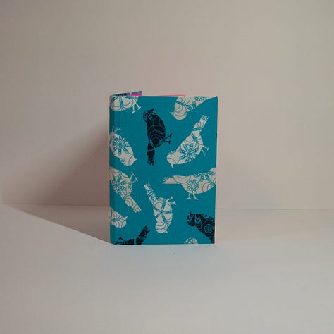 three different hand bound hard cover books.