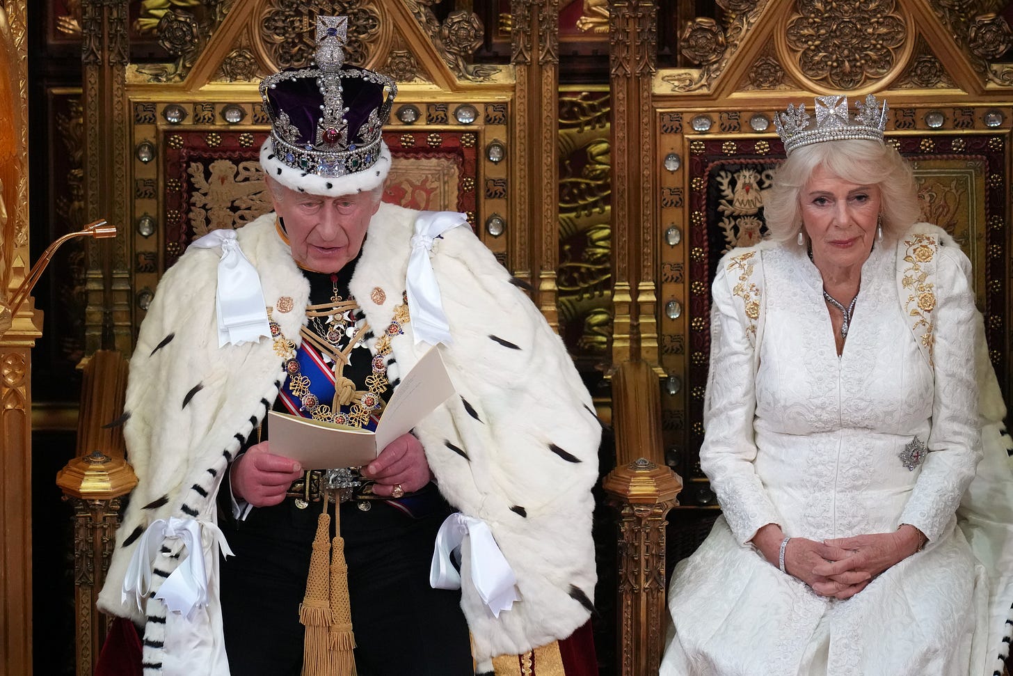 King Charles and Queen Camilla sat on thrones