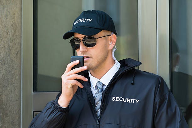 Security Guard Using Walkie-talkie Radio stock photo Security Guard Using Walkie-talkie Radio stock photo