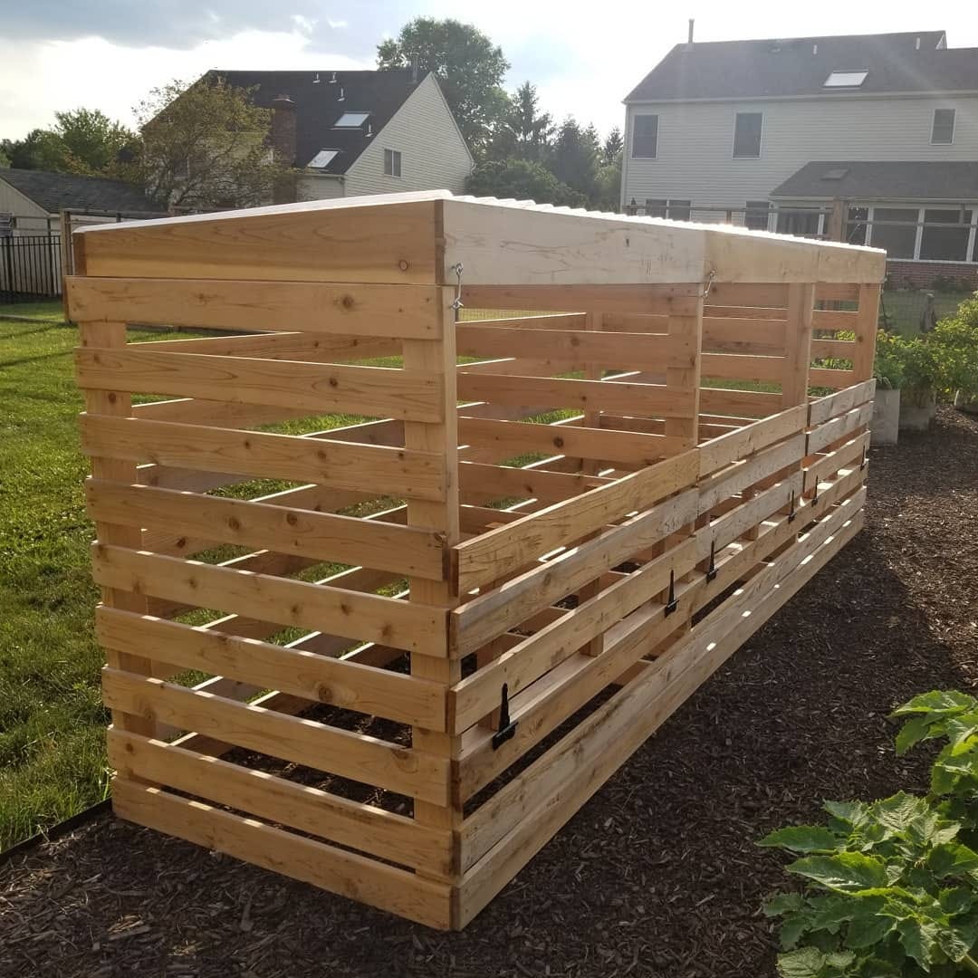 A wooden compost bin sits on the edge of a garden in the Philadelphia suburbs.