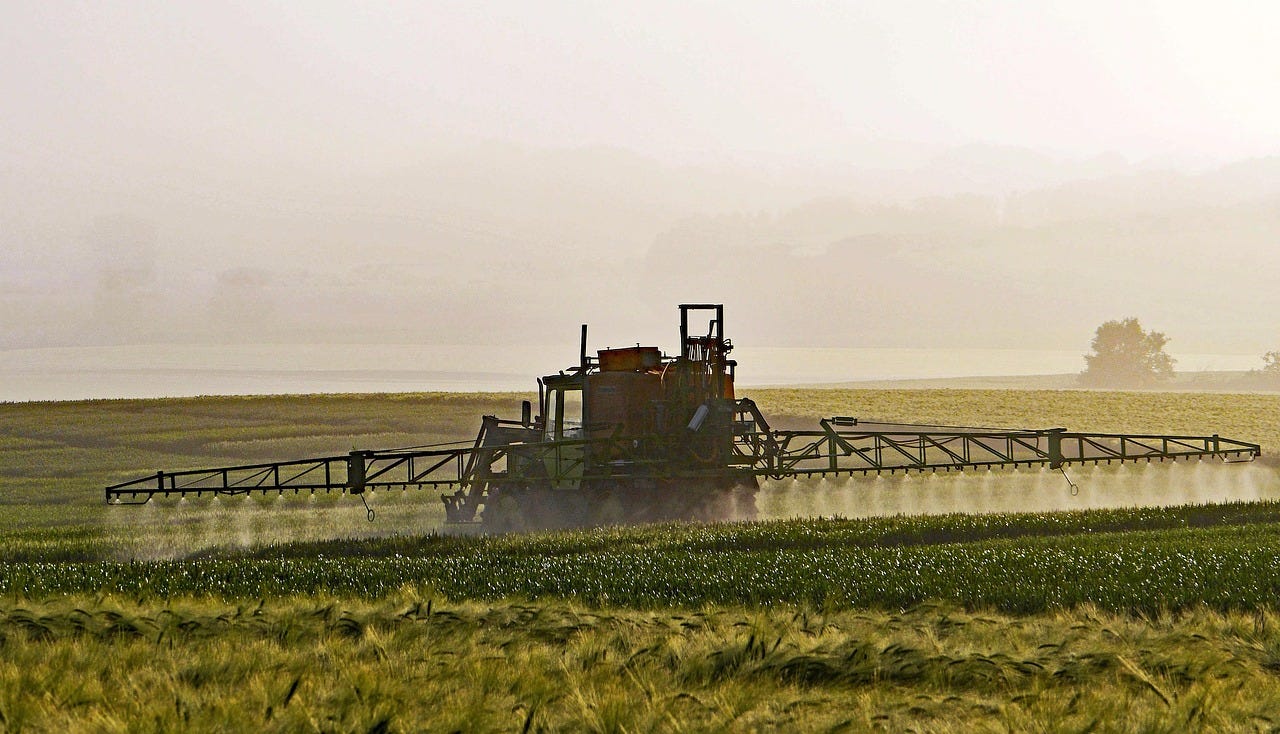 a tractor spraying a field a tractor spraying a field