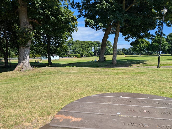 Two scoop of Alandas gelato in front of a lighthouse statue in North Berwick Lodge Gardens, then a view of the Lodge Gardens from a round wooden table