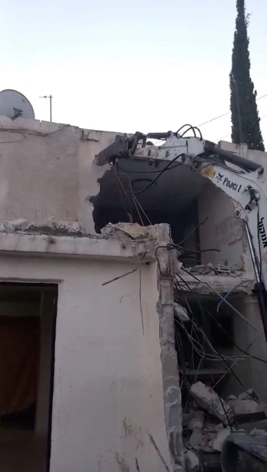 An excavator tearing into the upper floor of a house An excavator tearing into the upper floor of a house
