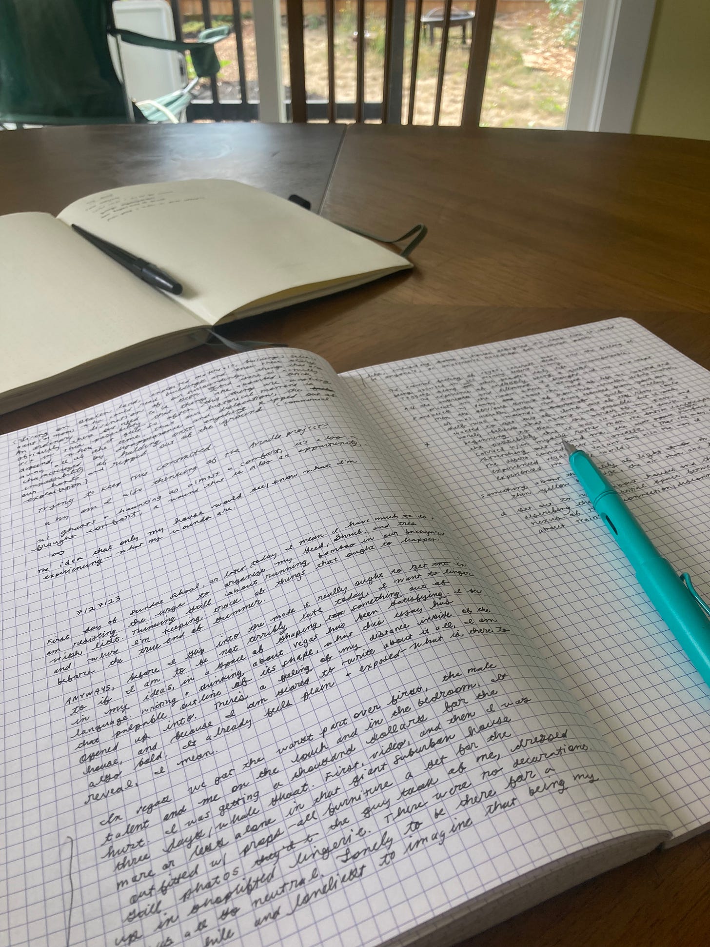 Two notebooks open on a kitchen table.