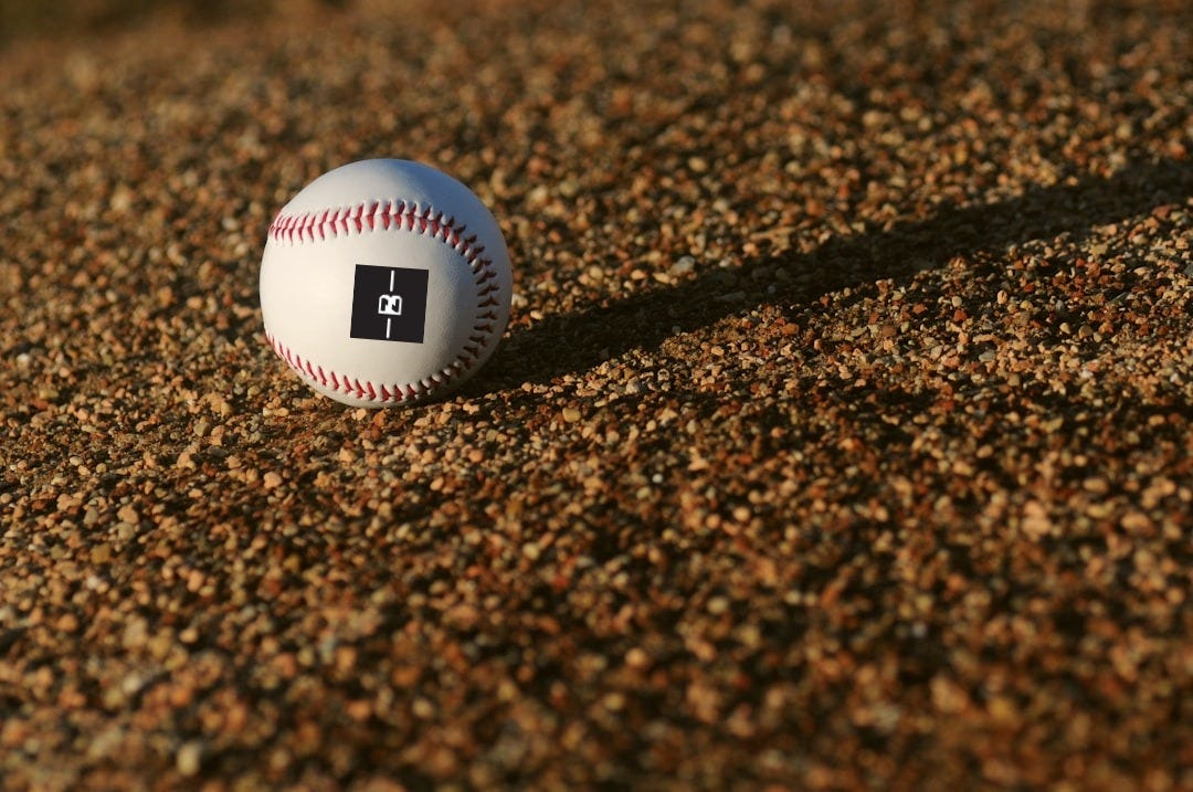white and red baseball on brown soil at daytime
