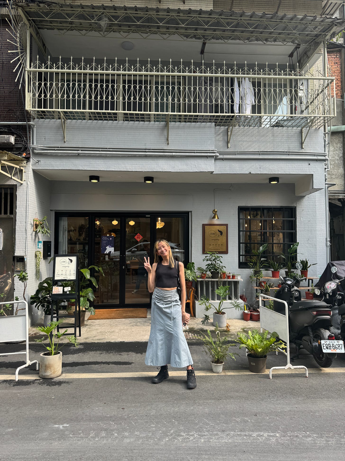 Yo-Yo standing outside a storefront wearing a cute long powder blue skirt and small black top. Its her birthday!