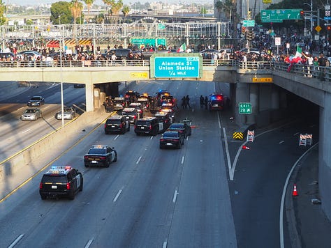 Protesters begin vandalizing police vehicles that are parked on the 101 freeway.