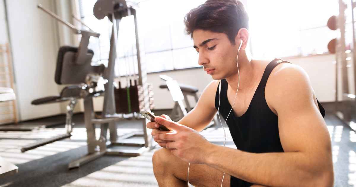 man in the gym holding smart phone
