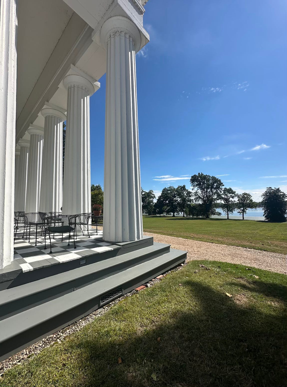 large white columns against a blue sky in a large garden