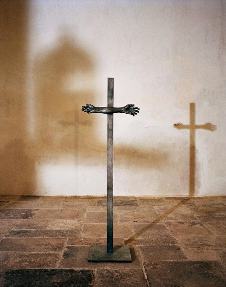 This may contain: the shadow of a cross is cast on the wall next to a crucifix