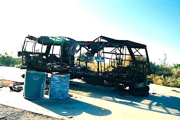 Burned-out bus with a No Trespassing sign on it Burned-out bus with a No Trespassing sign on it