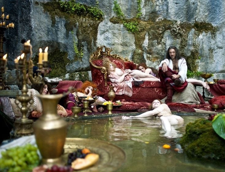 This may contain: a group of people sitting on top of a couch next to a pond filled with water