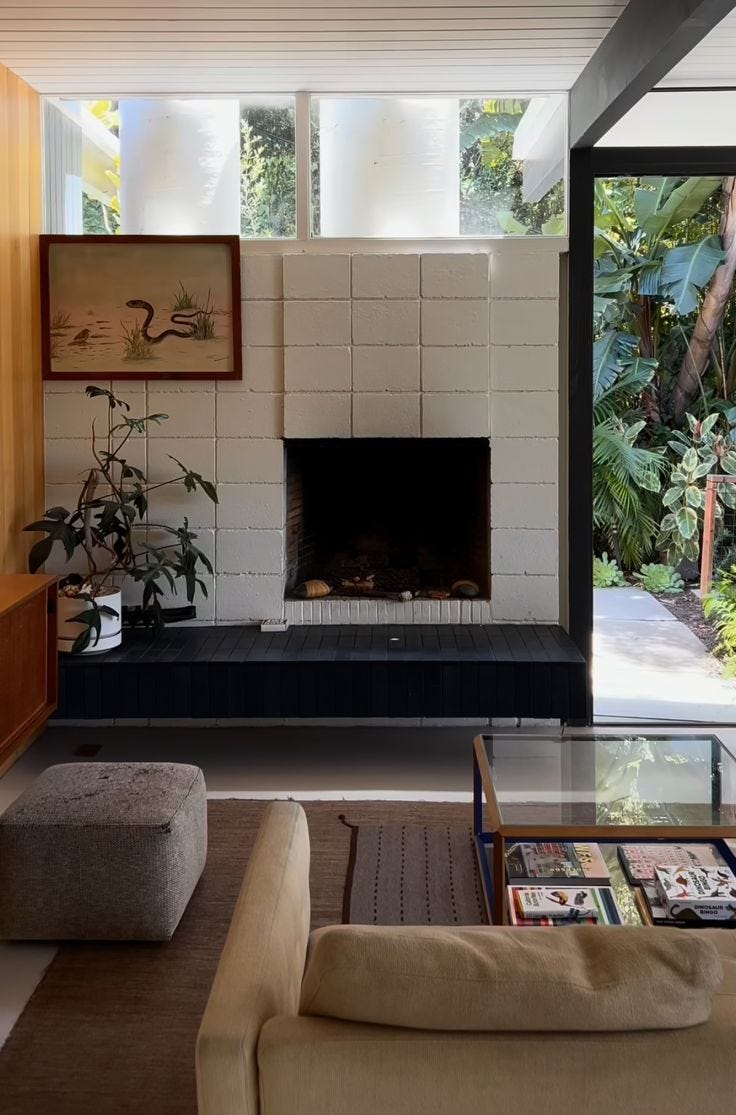 This may contain: a living room filled with furniture and a fire place next to a wall mounted tv