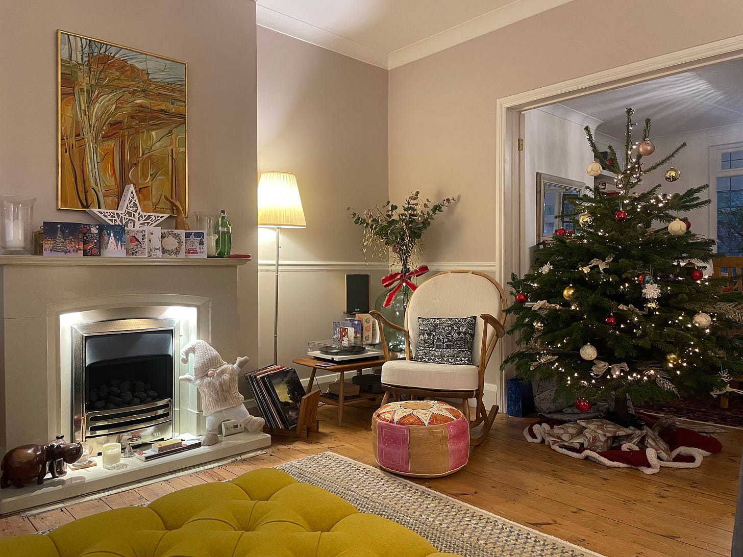 A view of a fireplace, rocking chair and Christmas tree