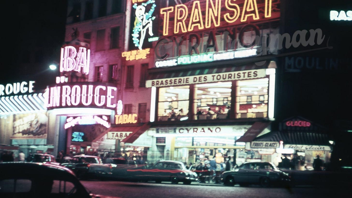 The vibrant and iconic Pigalle red-light district of Paris captured at night in the 1950s.