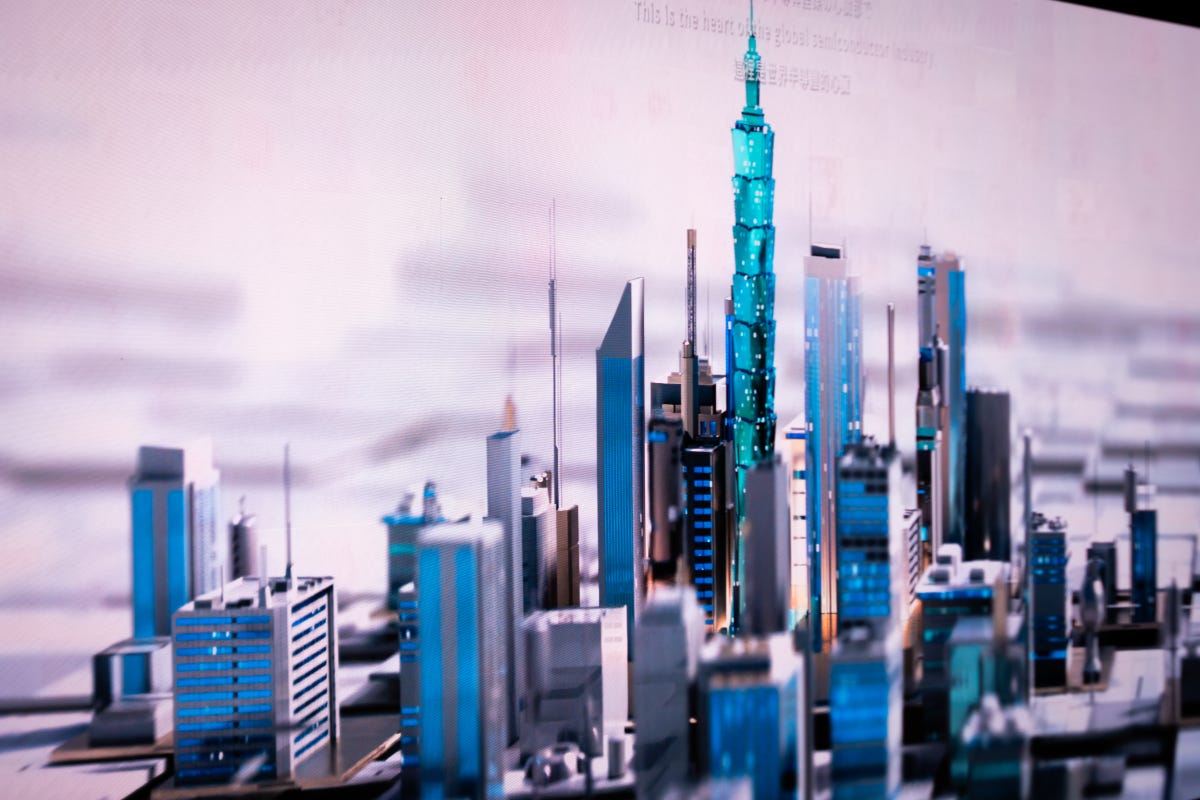 A 3D digital model of a cityscape, including Taipei 101, sits atop a semiconductor