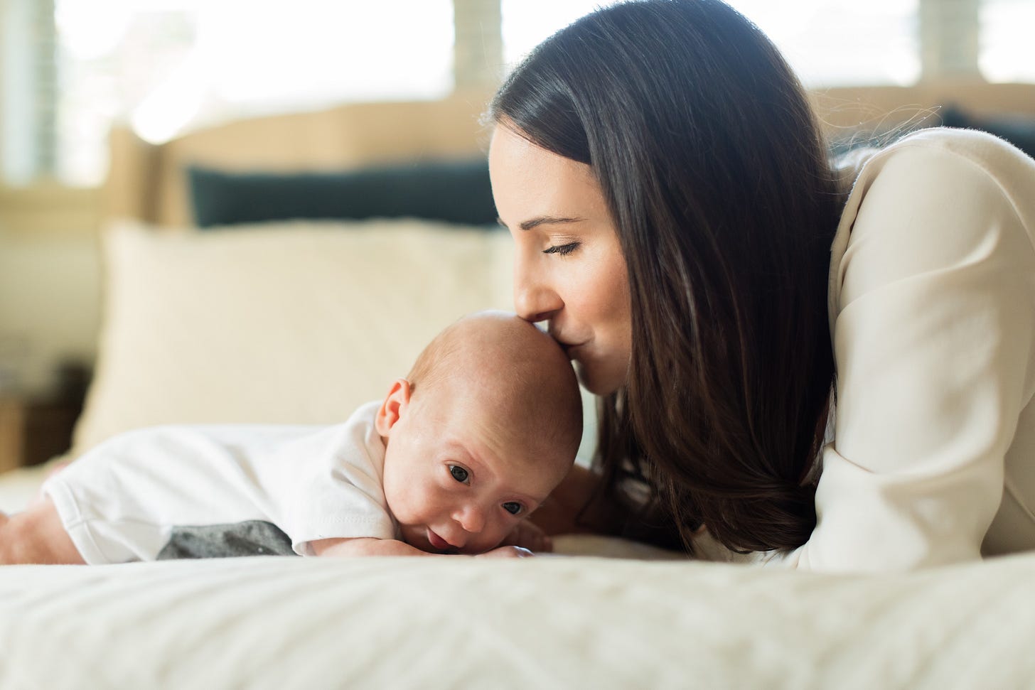A mother kissing her infant son on the head