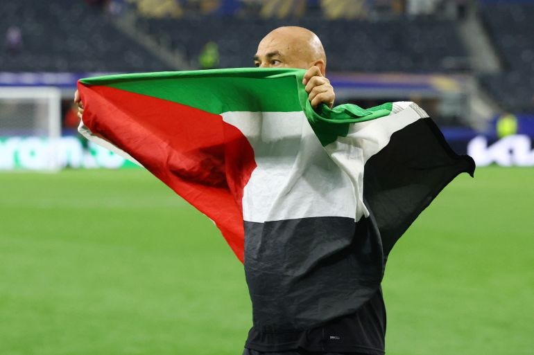 Soccer Football - FIFA World Cup 2026 - Round of 32 - Australia v Egypt - Dallas Stadium, Arlington, Texas, U.S. - July 3, 2026 Egypt coach Hossam Hassan celebrates with a Palestine flag after the match as Egypt qualify for the Round of 16 stage of the World Cup REUTERS/Hannah Mckay
