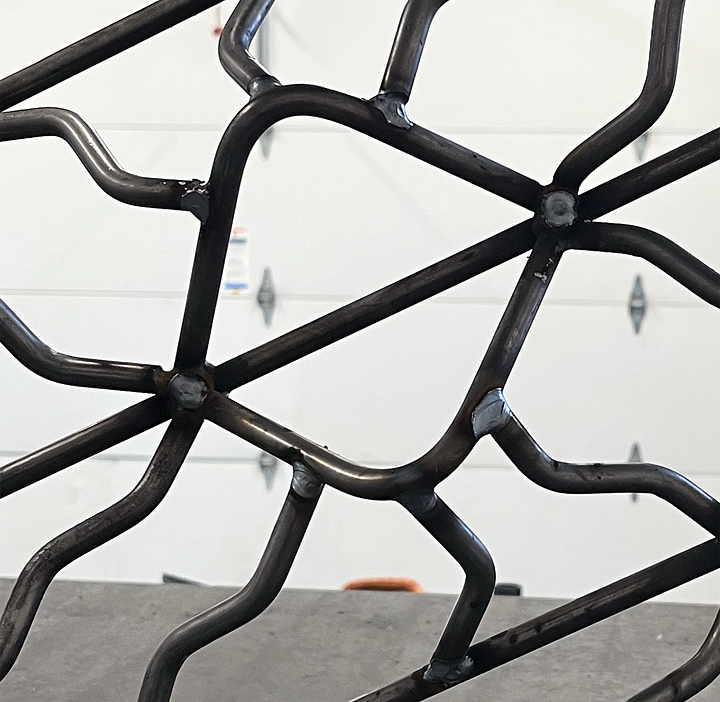 metal sculpture, pattern made of steel, diamond shape cut out in the steel pattern.