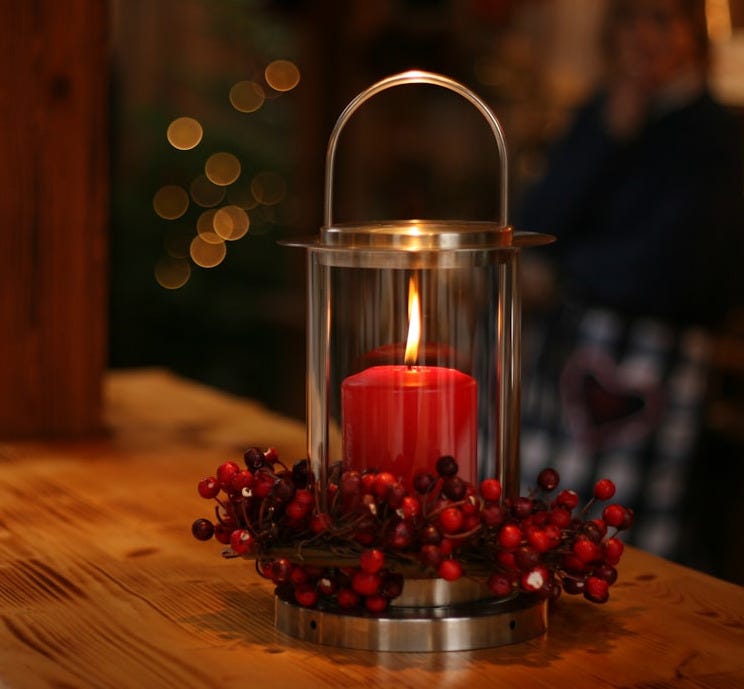 red lighted candle on brown wooden frame