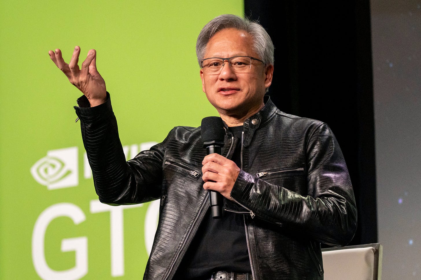 Jensen Huang speaking on stage at an NVIDIA GTC conference.