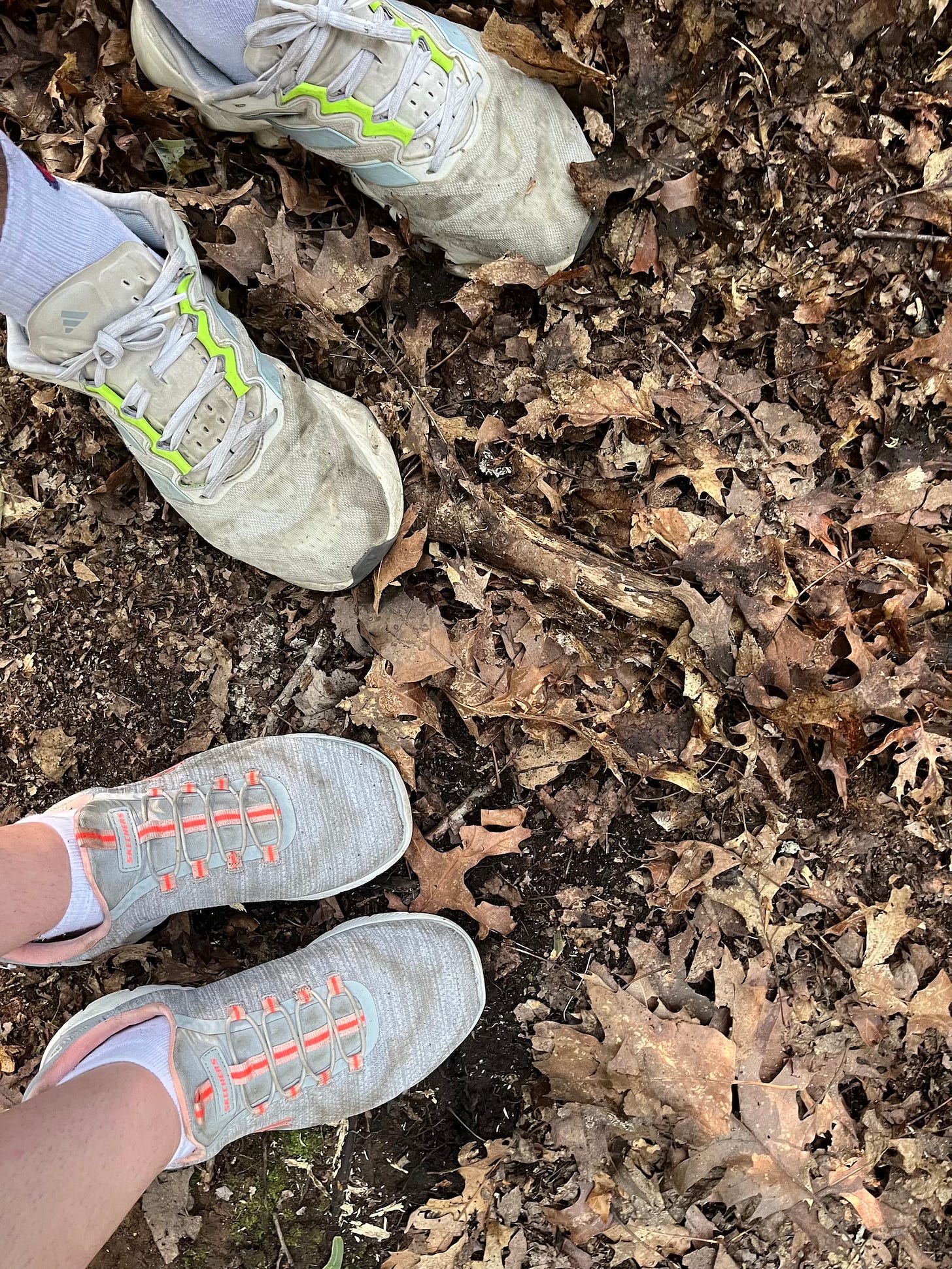two sets of feet, side by side, standing on leaves