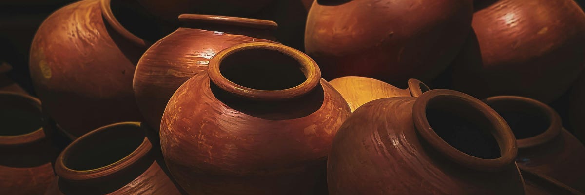 Stack of clay pots with warm light bouncing off them