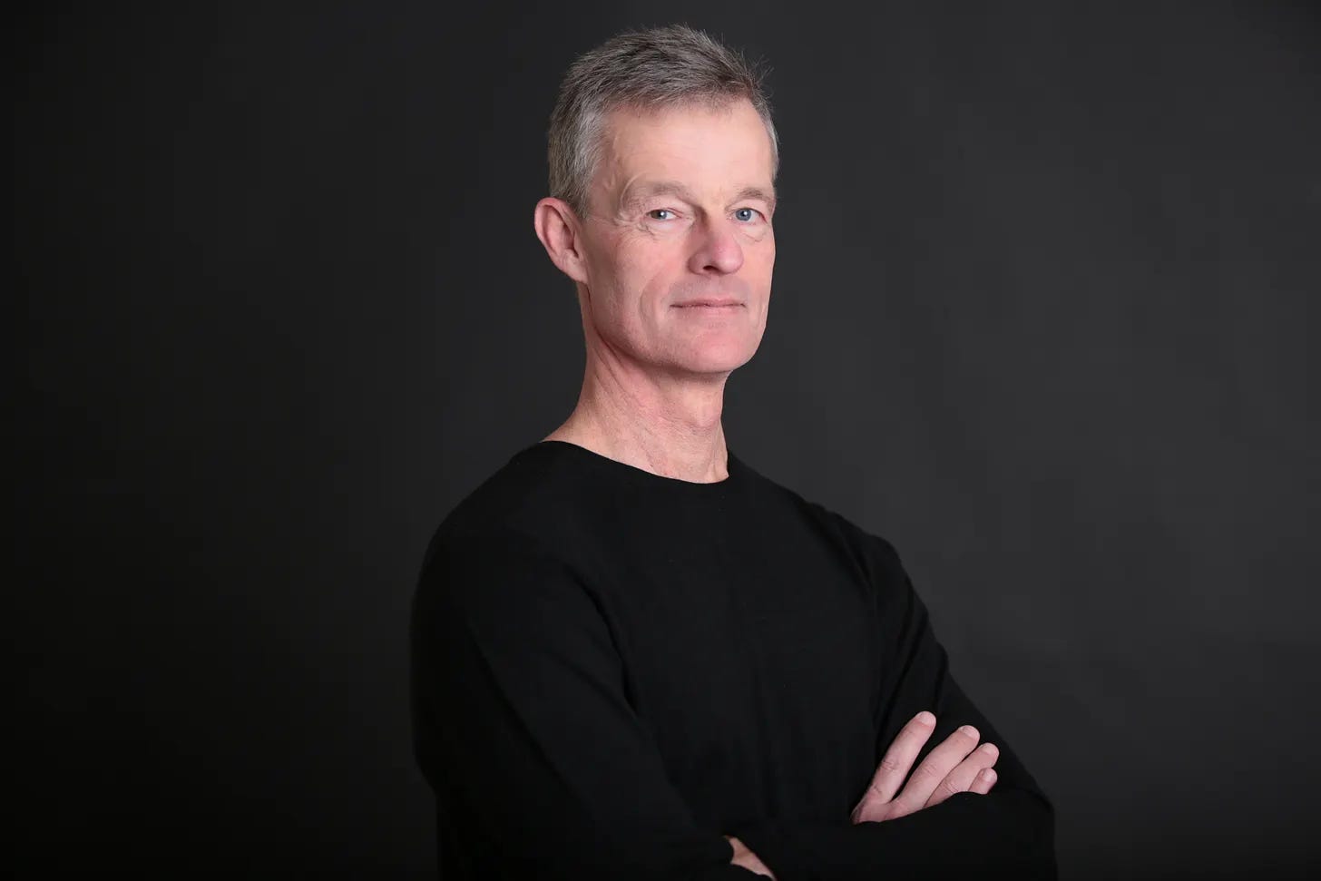 Portrait of Baba Tilo de Àjàgùnnà, founder of DAILY IFÁ, wearing a black shirt against a dark background. Portrait of Baba Tilo de Àjàgùnnà, founder of DAILY IFÁ, wearing a black shirt against a dark background.