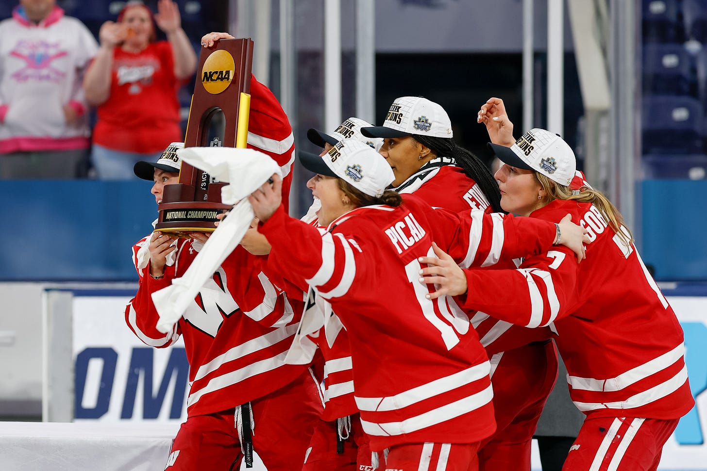 Five Wisconsin women's hockey players lift the national championship trophy