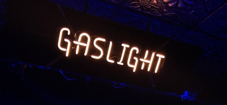 a stage with a blue curtain and a sign that reads gaslight a stage with a blue curtain and a sign that reads gaslight