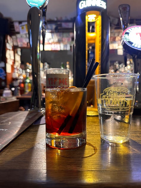 A negroni and a cup of water, my bar crawl group and a tip jar