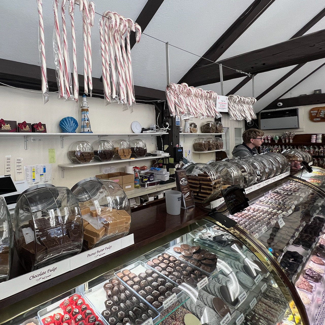 A candy store with candy canes and candy on shelves

Description automatically generated