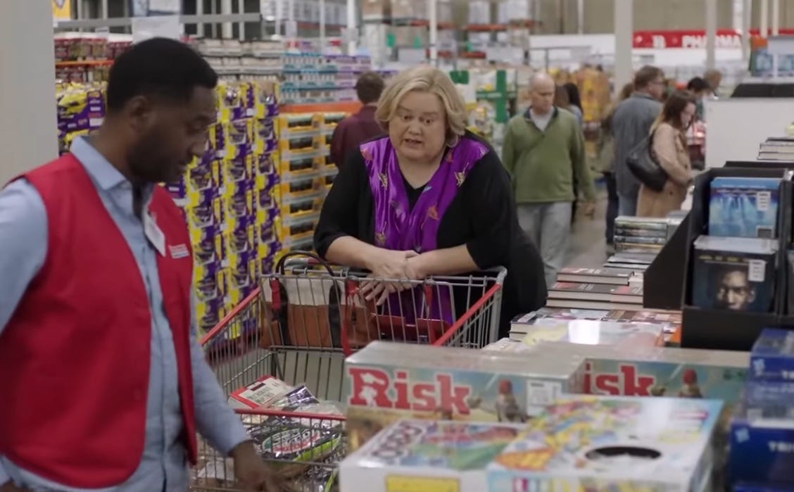 In a screenshot from the FX sittragicomedy 'Baskets,' Louie Anderson, as Christine Baskets, shops for a board game at Costco. The cavernous warehouse store is prolly very metaphorical and shit.