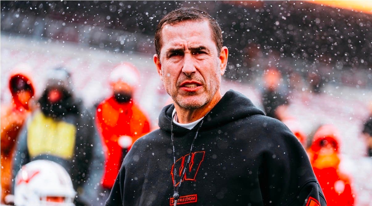 Wisconsin head coach Luke Fickell on the snowy field wearing a Badgers hoodie during the Minnesota matchup.
