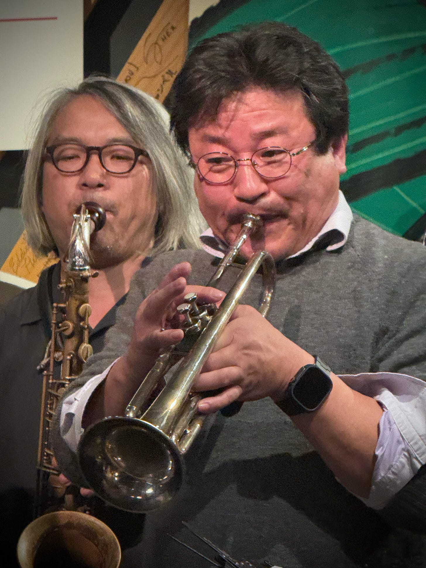 A person playing a trumpet with another person playing a saxophone

AI-generated content may be incorrect.