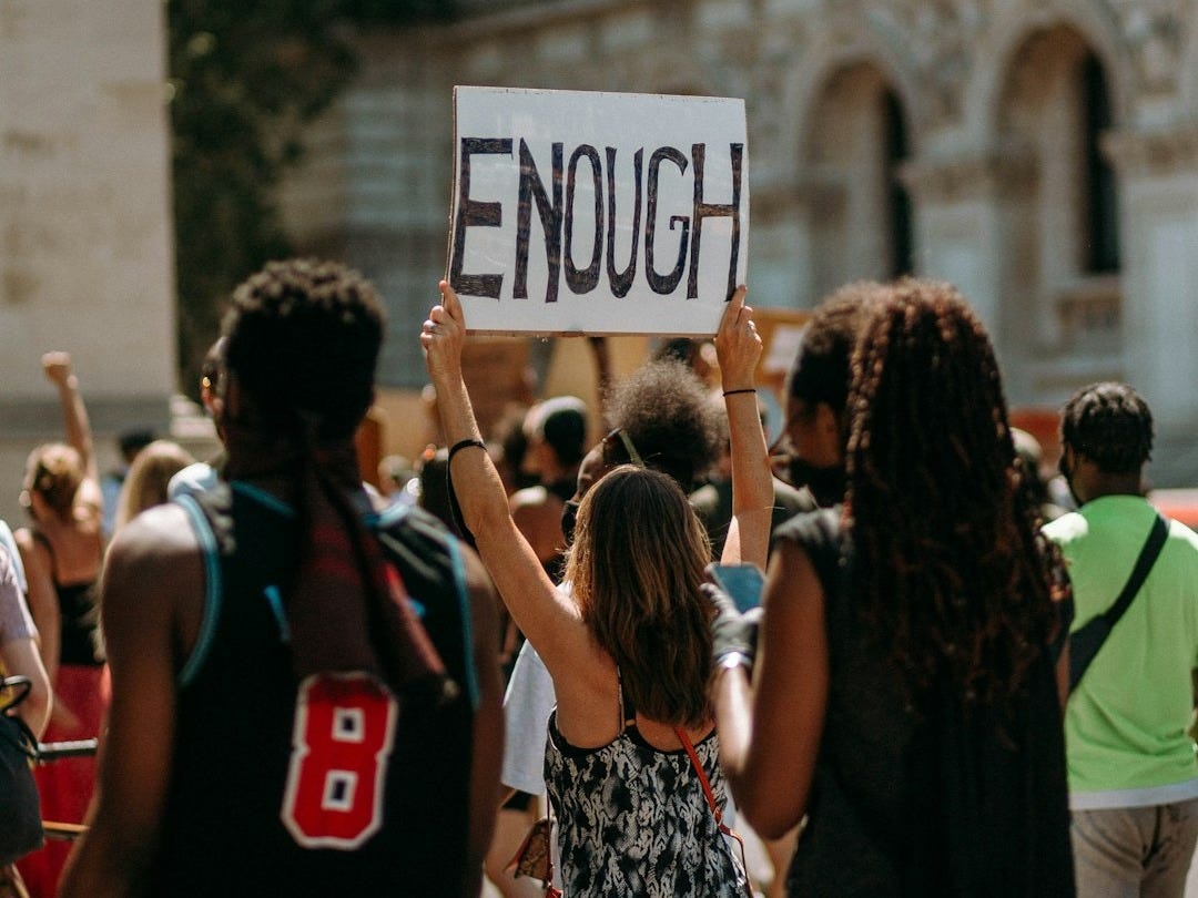 people holding a signage during daytime