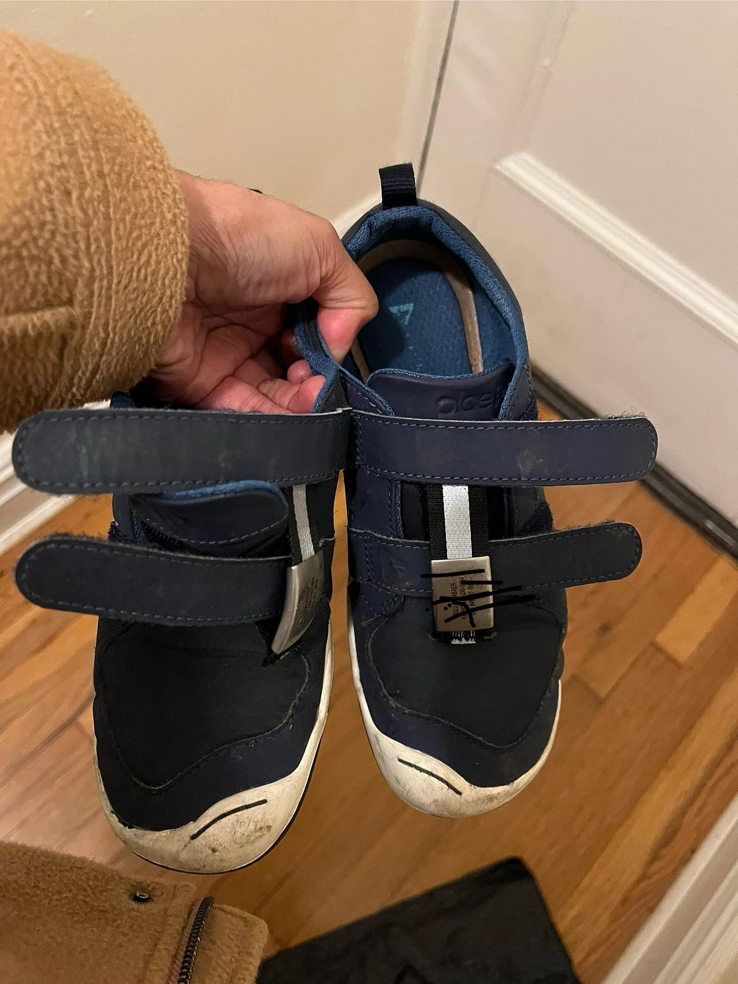 May be an image of wingtip shoes and duffle coat